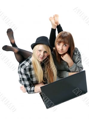Two girls lies with computer