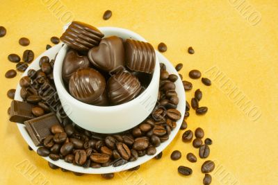 Cup full with coffee beans and chocolate candies