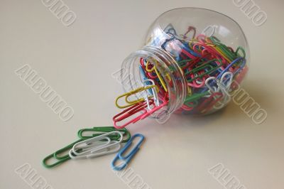 spilled colored paper clips jar