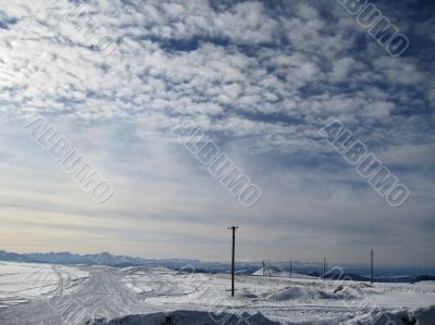 Blue sky with a little clouds and winter caucasus mountain lands