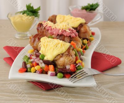 Chicken leg wrapped in bacon with vegetables and different sauce