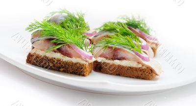 Sandwiches of rye bread with herring, onions and herbs.