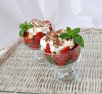 Strawberries with biscuit pieces with mint whipped cream under