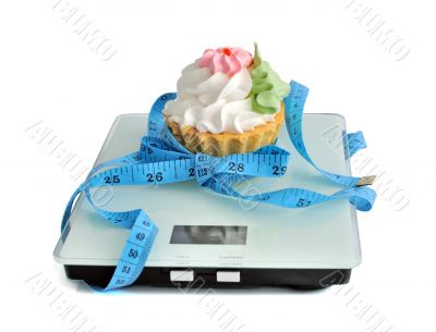 Cake on the scales measuring tape wrapped