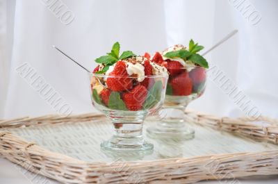 Strawberries with biscuit pieces with mint whipped cream under