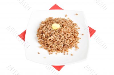 Appetizing crumbly buckwheat with butter on white background