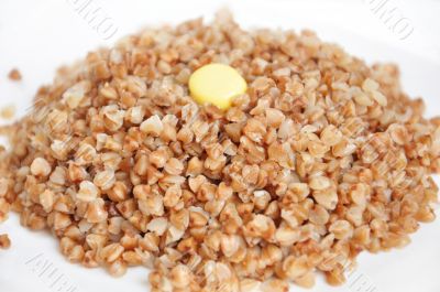 Appetizing crumbly buckwheat with butter on white background