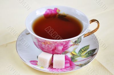 A cup of tea and sugar in isolation on a white background