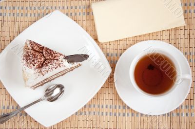 Tea and a slice of cake with cream