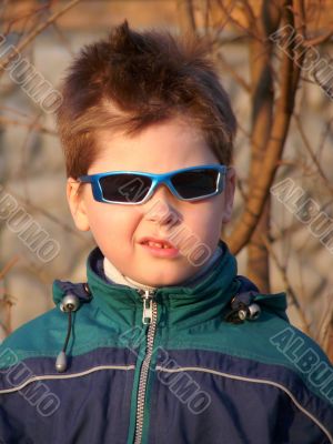 A boy with glasses with a grimace on his face