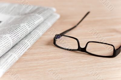 Eyeglasses lying around newspapers