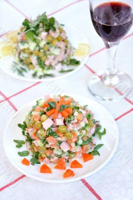 A delicious salad with mayonnaise and a glass of red wine
