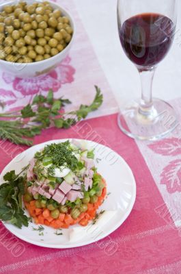A delicious salad with mayonnaise and a glass of red wine