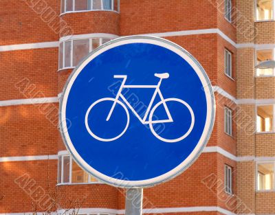 The sign of a cycle track on the background of a brick high-rises 