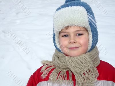 Portrait of a boy in winter clothing against the backdrop of the snow,