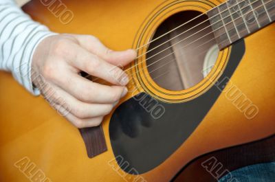 A man plays the six string guitar