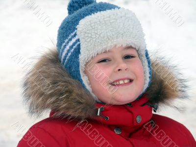 Portrait of a boy in winter clothing against the backdrop of snow 