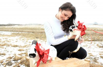 A beautiful woman next to two white rabbits