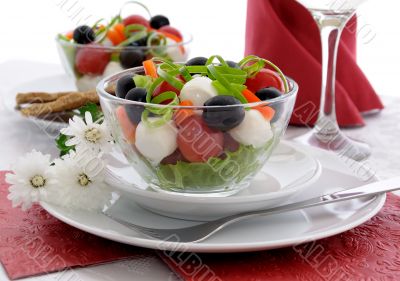Salad of lettuce, cherry tomatoes, olives and mozzarella with pe