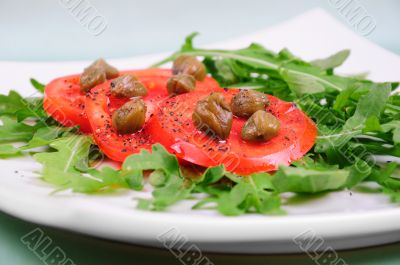 Salad with fresh tomatoes, capers and arugula