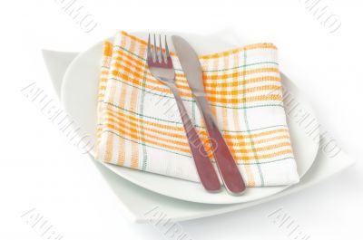 Napkin, folded on a plate with knife and fork 