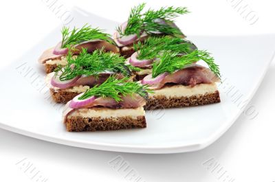 Sandwiches of rye bread with herring, onions and herbs.