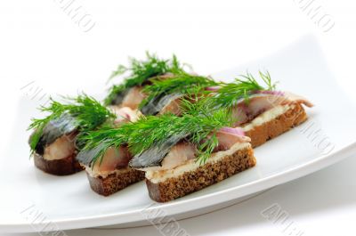 Sandwiches of rye bread with herring, onions and herbs.