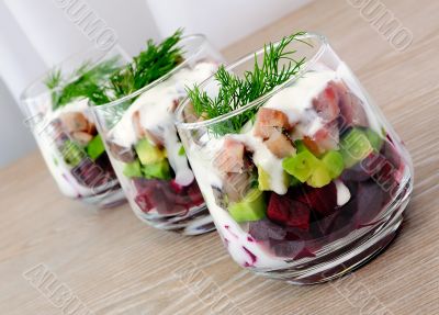 Appetizer in a glass of beet and herring with avocado