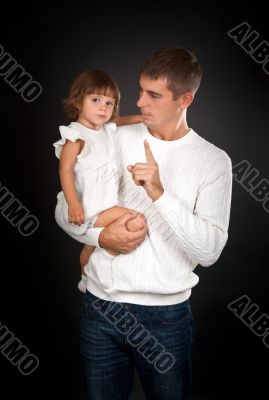 Father shaking his finger at a small daughter