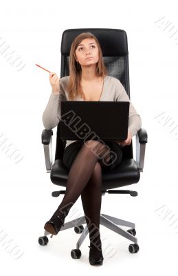 Young business lady in a chair with a laptop