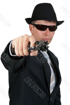 businessman in a hat and sunglasses with a gun