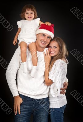 Father in santa hat holding little girl on his shoulder and hugg