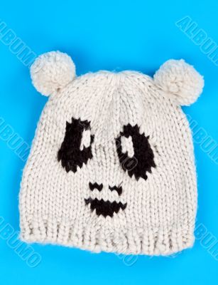 knitted wool hat with a pattern of little faces