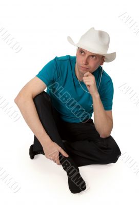 man in a cowboy hat sitting in the lotus position