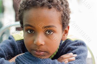 Portrait of an Ethiopian boy resting his chin on his hands