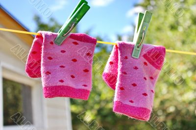 Pink baby sock hanging on the clothesline