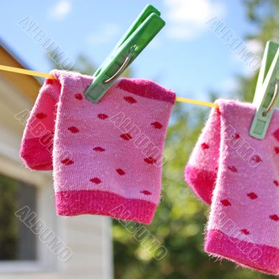 Pink baby sock hanging on the clothesline