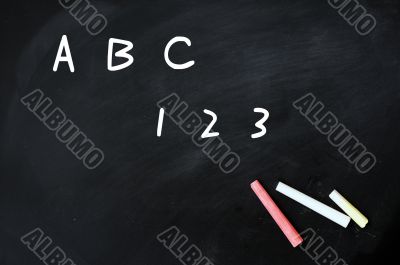 ABC and 123 handwritten with white chalk on a blackboard