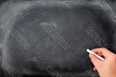Blackboard background with a hand hold chalk