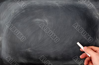 Blackboard background with a hand hold chalk