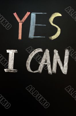 Chalk handwriting of `YES I CAN` on a blackboard 