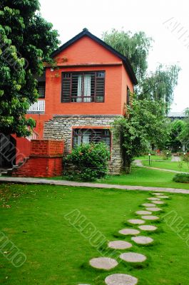 Red house with green meadows