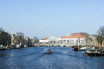 Amsterdam city in the Netherlans, boat in the river Amstel Amsterdam city in the Netherlans, boat in the river Amstel