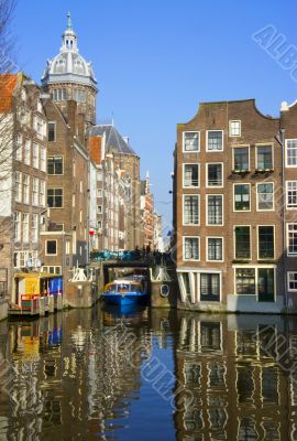 Blue boat on channel in Amsterdam. Typical Amsterdam architectur