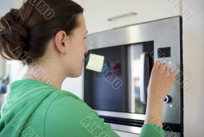 woman cooking with a microwave in a modern kitchen