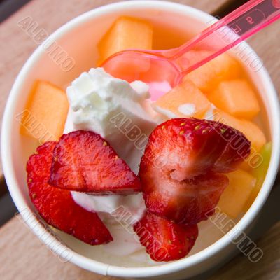 Delicious ice cream with strawberry and melon topping