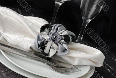 Decorative folded napkin on a plate with cutlery