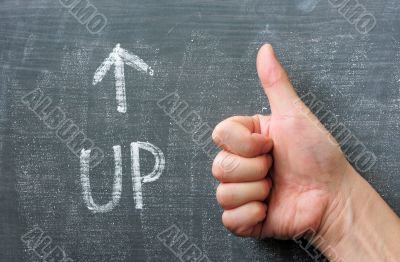 Up - word written on a blackboard with an arrow and thumb up gesture