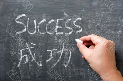 Success - word written on a blackboard with a Chinese translation