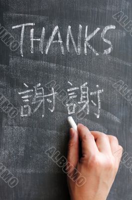 Thanks - word written on a blackboard with a Chinese version Thanks - word written on a blackboard with a Chinese version